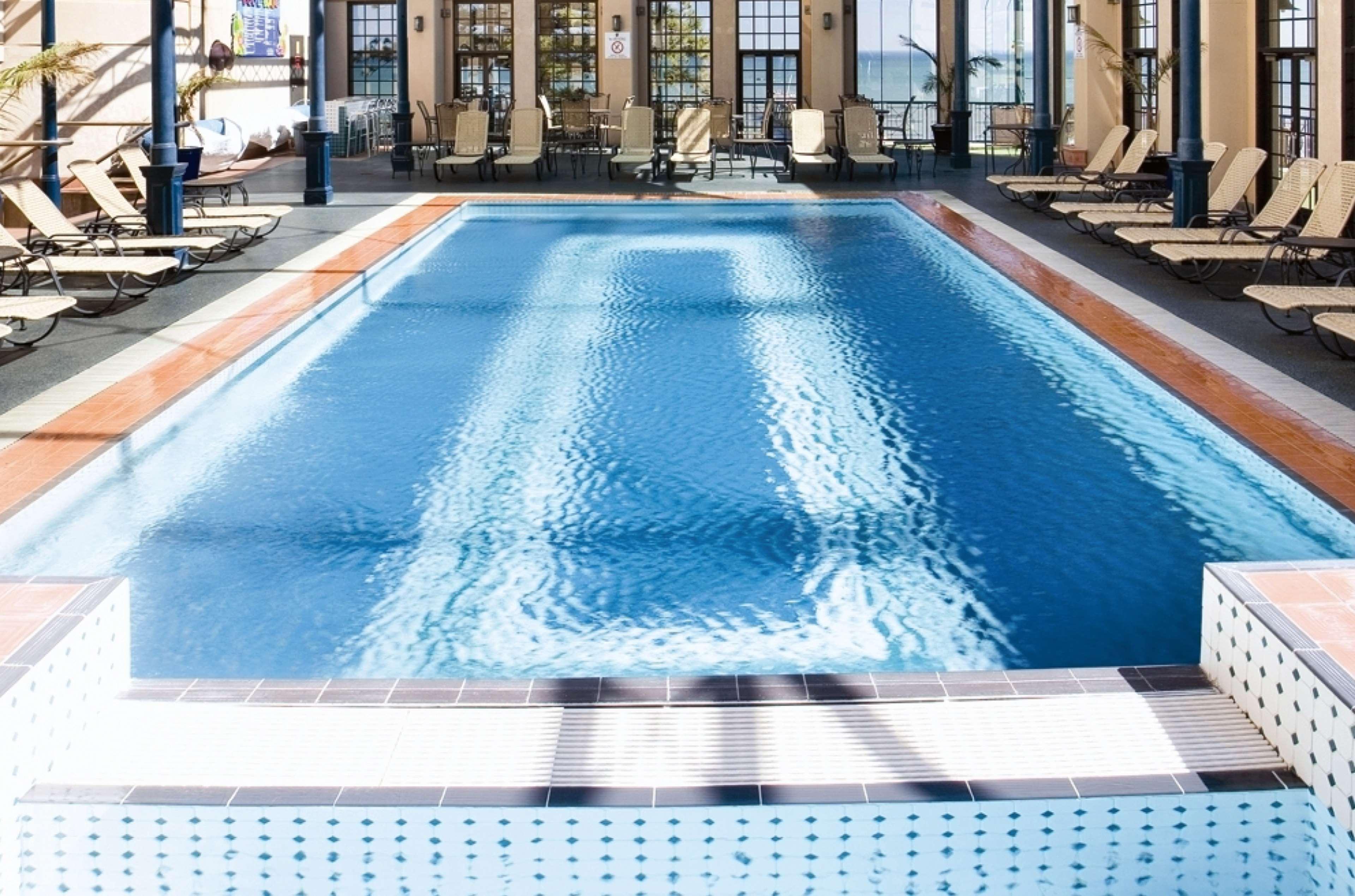Готель Stamford Grand Adelaide Ґленелґ Екстер'єр фото The photo shows an indoor swimming pool with a pristine blue surface. The pool is surrounded by a tiled deck and has lounge chairs lined up along the sides. Large windows allow natural light to flood the area, creating a bright and inviting atmospher
