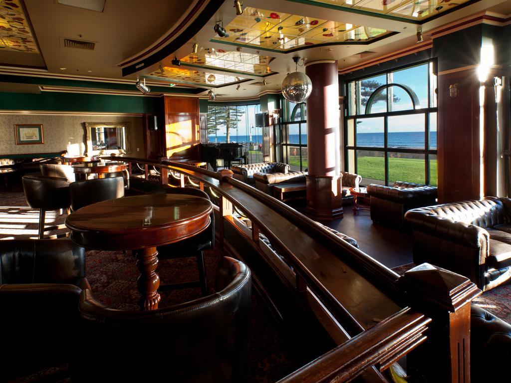 Готель Stamford Grand Adelaide Ґленелґ Екстер'єр фото The photo depicts a stylish and inviting interior of a lounge or bar. It features comfortable leather seating, wooden tables, and large windows that provide a view of the outdoors. The ceiling is adorned with decorative elements, and there’s a disco 